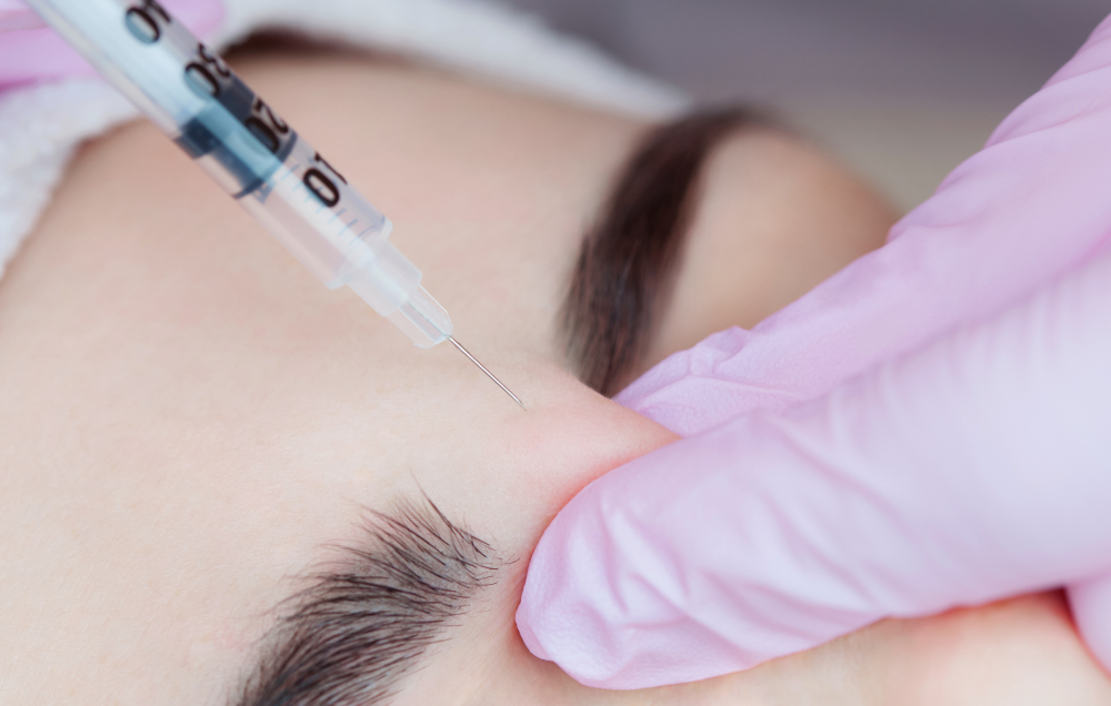Client receiving a facial assessment before injectable treatment in a calm studio setting